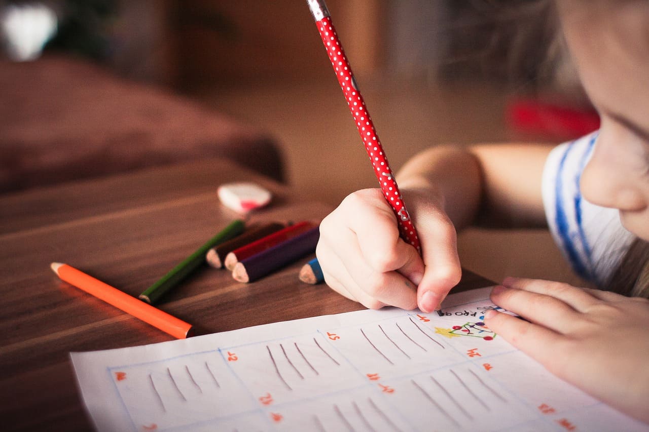 immagine di una bambina concentrata a disegnare